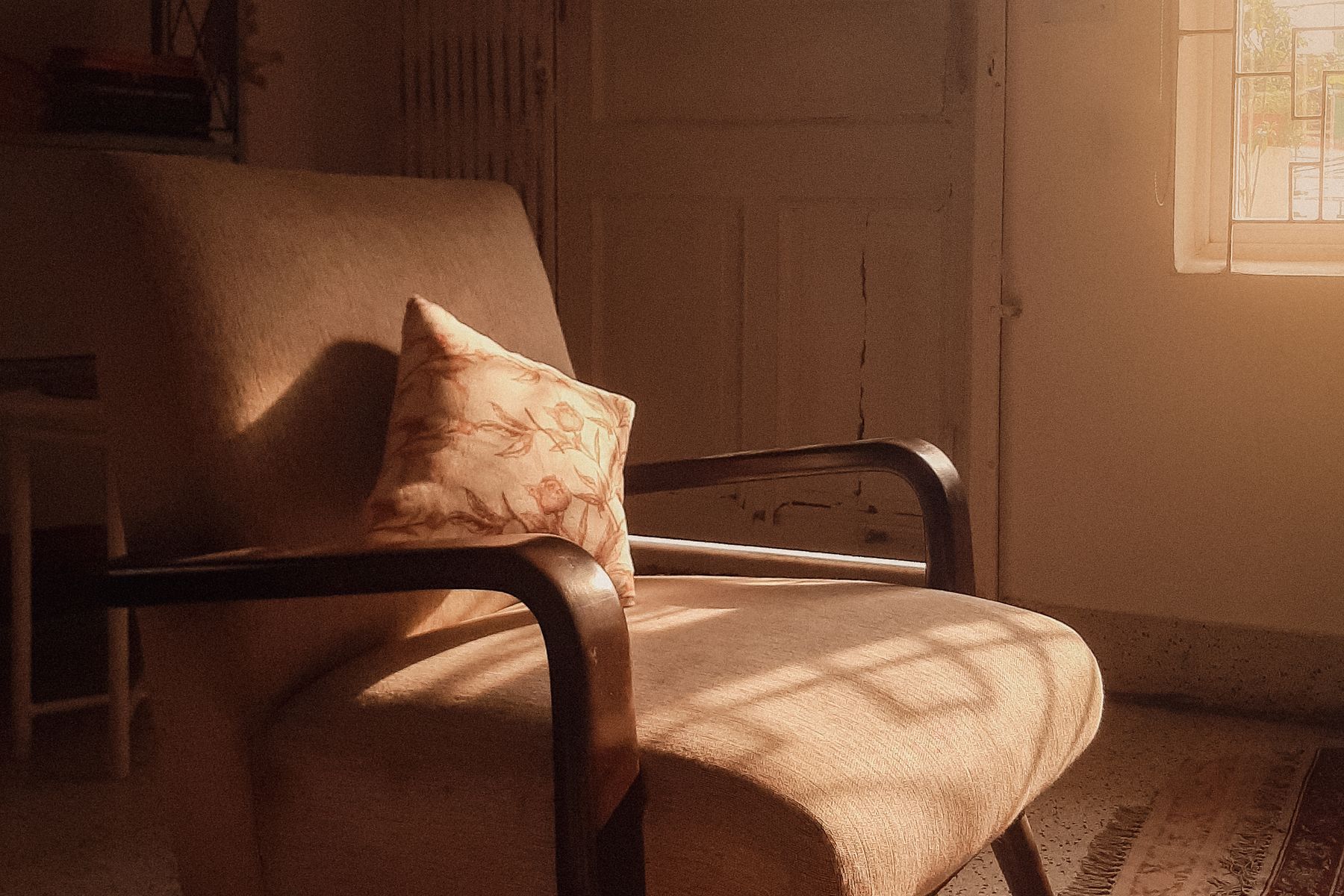 Un fauteuil près d'une fenêtre, dans une lumière chaude de fin d'après-midi