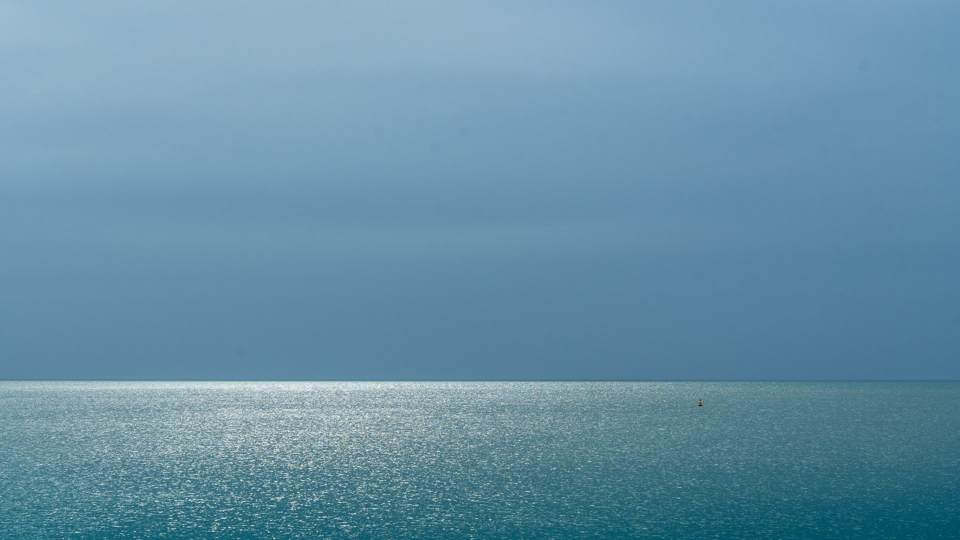 La mer sous un ciel gris, à l'horizon dégagé